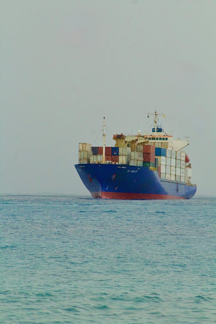 A large cargo ship filled with containers sailing on open waters.
