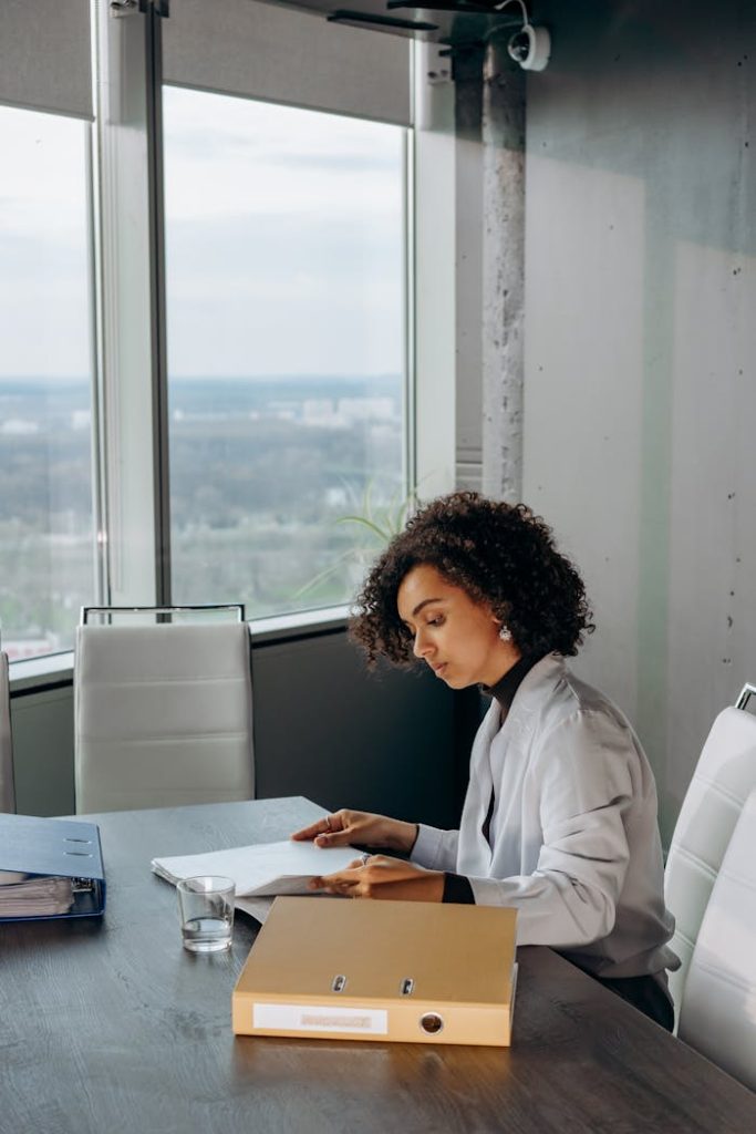 African American woman reviewing documents at a desk in a modern office.